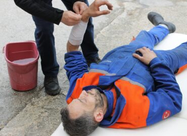 Ein Mann liegt nach einem Arbeitsunfall verletzt auf dem Boden.